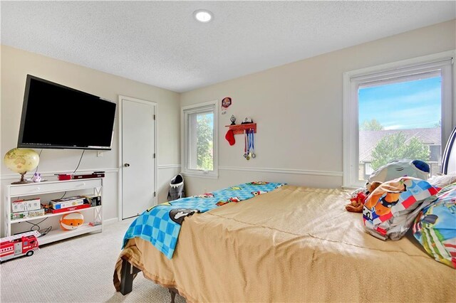 carpeted bedroom featuring a textured ceiling
