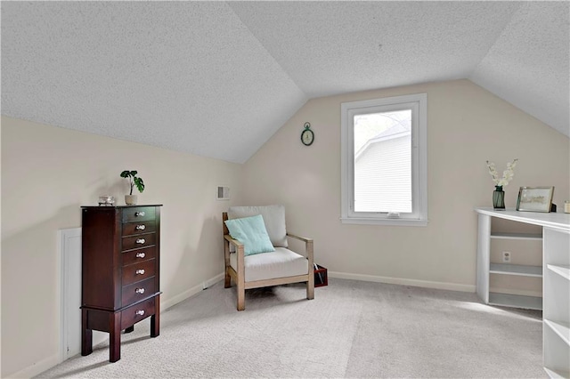 sitting room with baseboards, carpet flooring, a textured ceiling, and lofted ceiling