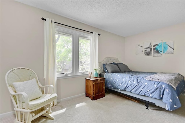 bedroom featuring carpet flooring, a textured ceiling, and baseboards