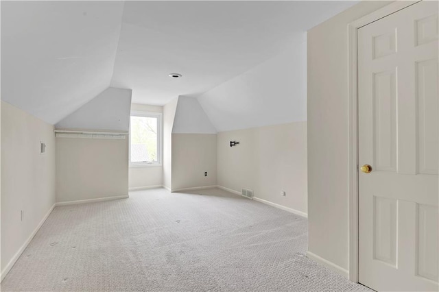 additional living space with baseboards, carpet, and lofted ceiling