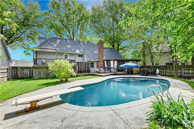 view of swimming pool featuring a deck, a patio, a fenced backyard, a fenced in pool, and a yard