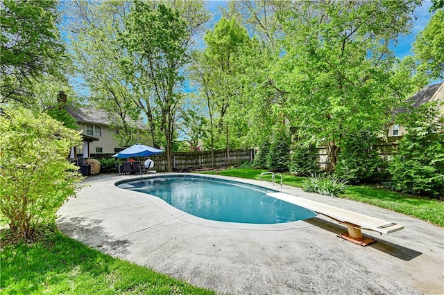 view of swimming pool featuring a fenced backyard, a fenced in pool, a diving board, and a patio