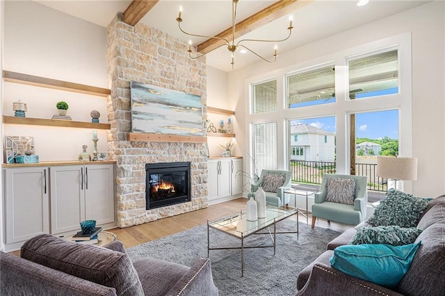 2315 SW Serena Pl, Lees Summit, MO 64082 - living room with beamed ceiling, a stone fireplace, light wood-style floors, a high ceiling, and a chandelier