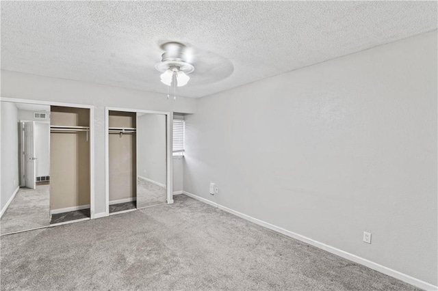 4727 Jarboe St Unit 52, Kansas City, MO 64112 - unfurnished bedroom with multiple closets, carpet floors, a textured ceiling, baseboards, and ceiling fan