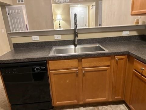 kitchen with dark countertops, dishwasher, brown cabinetry, and a sink