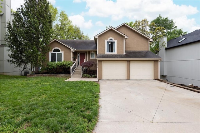 split level home with a garage, a front lawn, stucco siding, and concrete driveway