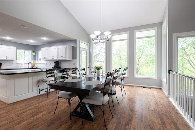 dining space featuring visible vents, wood finished floors, vaulted ceiling, and a wealth of natural light