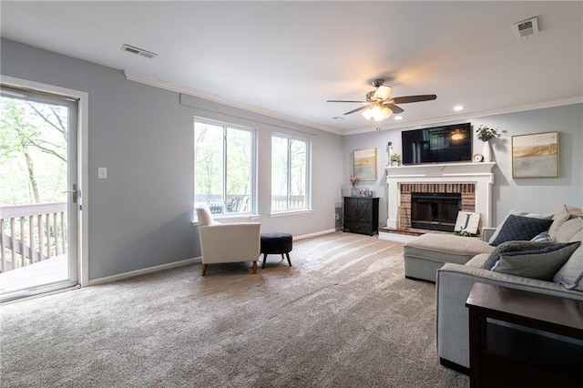 carpeted living room with crown molding, visible vents, a fireplace, and a wealth of natural light