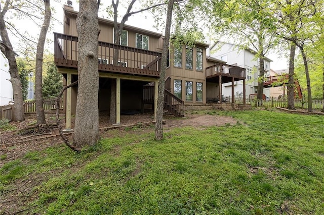back of house with fence, a lawn, a deck, and stairway