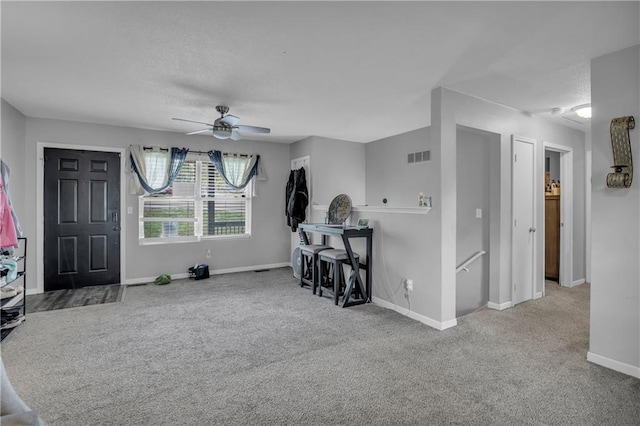 interior space with baseboards, a ceiling fan, visible vents, and a textured ceiling