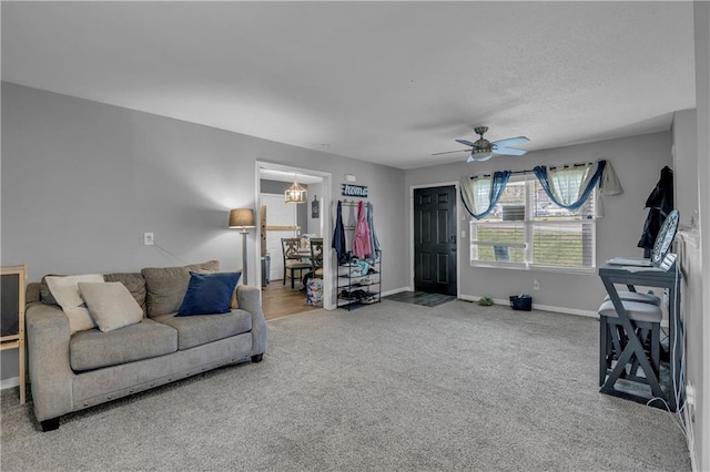 carpeted living area with baseboards and ceiling fan