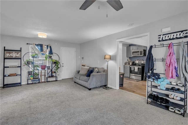 living area with baseboards, carpet flooring, and ceiling fan