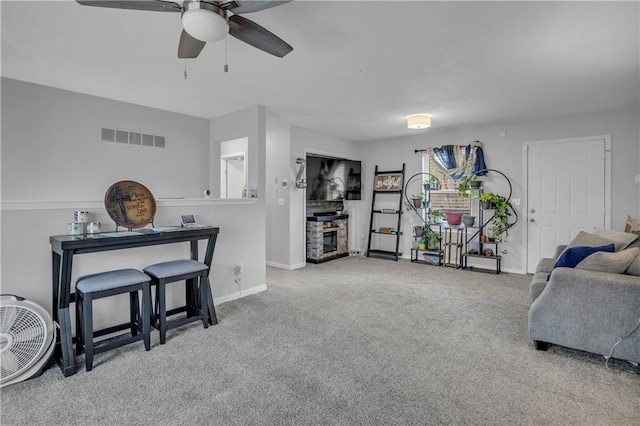 living area featuring baseboards, a ceiling fan, carpet flooring, and visible vents