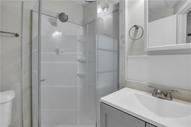 full bathroom featuring toilet, vanity, and a stall shower