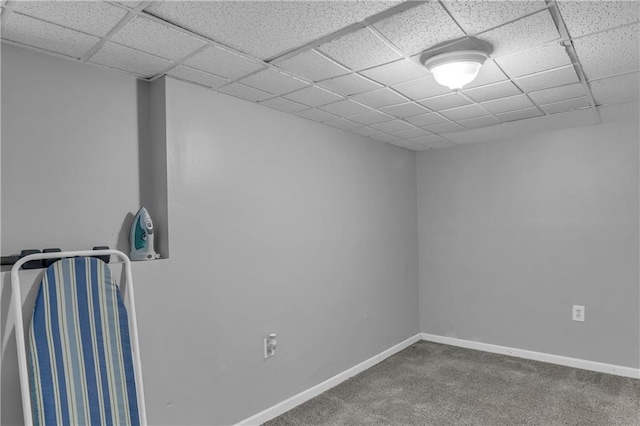 carpeted empty room with a paneled ceiling and baseboards