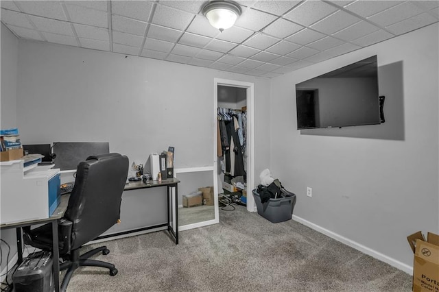 carpeted office space featuring baseboards and a paneled ceiling
