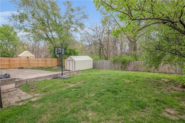 view of yard featuring a fenced backyard, an outbuilding, a patio, and a storage unit