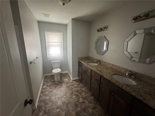 bathroom with toilet, a sink, visible vents, and double vanity