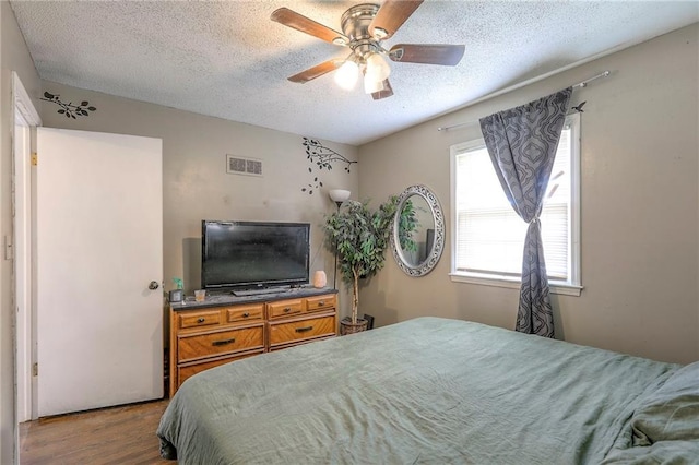 6606 E 135th St, Grandview, MO 64030 - bedroom with a textured ceiling, wood finished floors, and ceiling fan