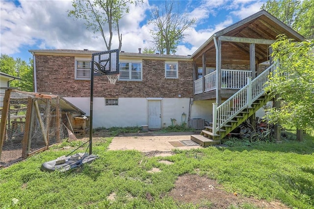 6606 E 135th St, Grandview, MO 64030 - back of house featuring brick siding, stairs, central AC unit, and a lawn