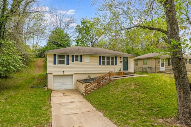 view of front of property featuring a front yard, driveway, an attached garage, and fence