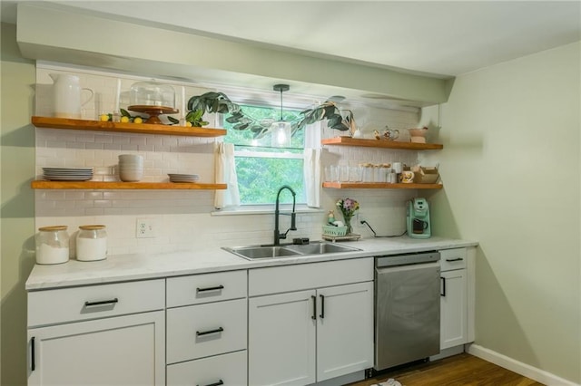 bar featuring a sink, dark wood-style flooring, backsplash, baseboards, and dishwasher