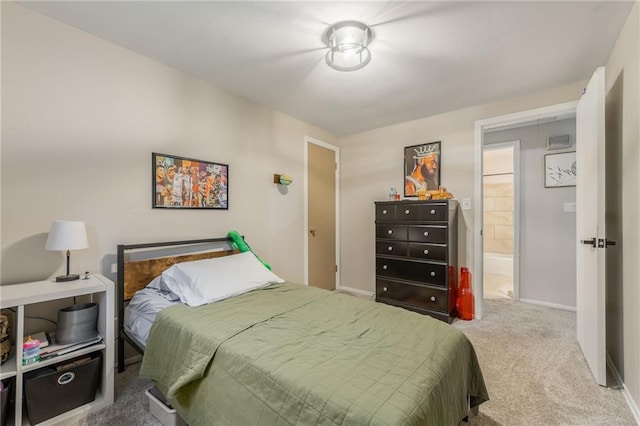 carpeted bedroom with ensuite bath and baseboards