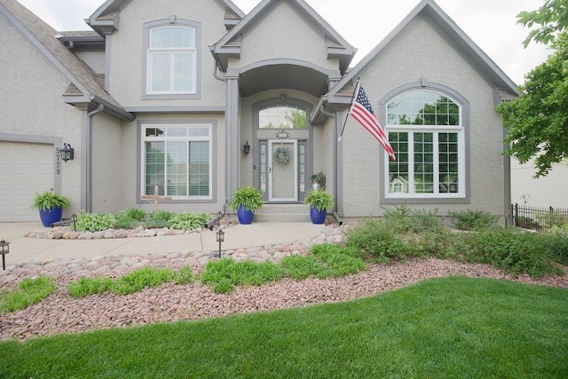 5720 NE Quartz Dr, Lees Summit, MO 64064 - doorway to property with a yard, fence, and stucco siding