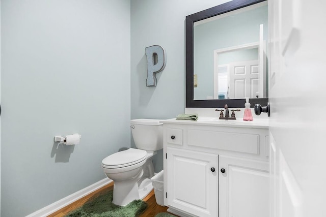 5720 NE Quartz Dr, Lees Summit, MO 64064 - bathroom featuring toilet, baseboards, wood finished floors, and vanity