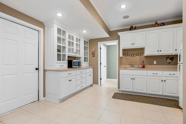 5720 NE Quartz Dr, Lees Summit, MO 64064 - kitchen featuring crown molding, white cabinets, light countertops, stainless steel microwave, and glass insert cabinets