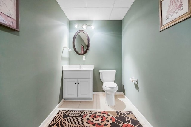 5720 NE Quartz Dr, Lees Summit, MO 64064 - bathroom with vanity, toilet, tile patterned floors, baseboards, and a drop ceiling