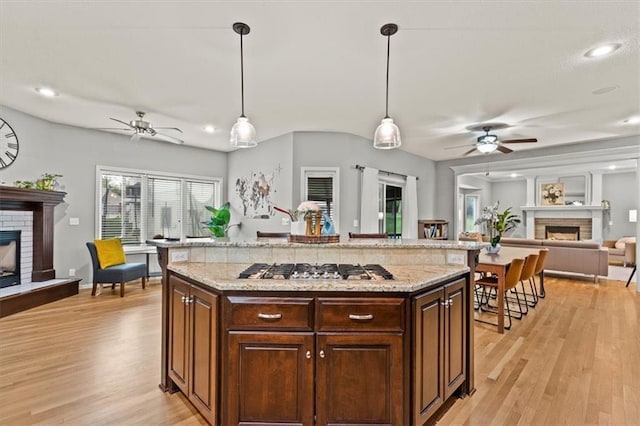 12544 Grand Ct, Kansas City, MO 64145 - kitchen featuring a fireplace, a ceiling fan, and stainless steel gas cooktop
