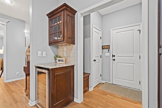 12544 Grand Ct, Kansas City, MO 64145 - interior space with baseboards, tasteful backsplash, light wood-style floors, and wine cooler