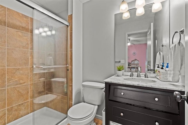 12544 Grand Ct, Kansas City, MO 64145 - bathroom featuring a shower stall, ceiling fan, toilet, and vanity