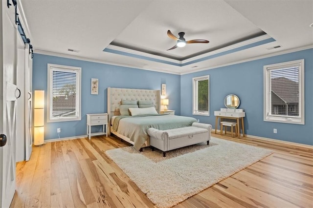 12544 Grand Ct, Kansas City, MO 64145 - bedroom with a barn door, visible vents, crown molding, hardwood / wood-style floors, and a raised ceiling