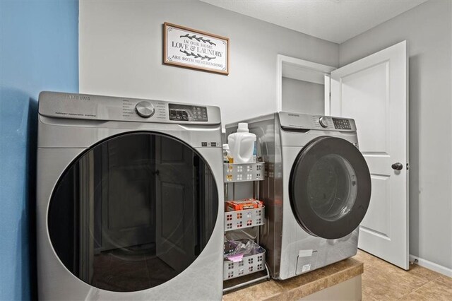 12544 Grand Ct, Kansas City, MO 64145 - washroom featuring light tile patterned floors, baseboards, laundry area, and independent washer and dryer