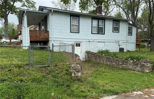 view of side of property with fence, a chimney, and a yard