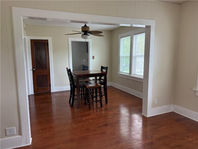 dining space featuring baseboards, dark wood-style flooring, and ceiling fan