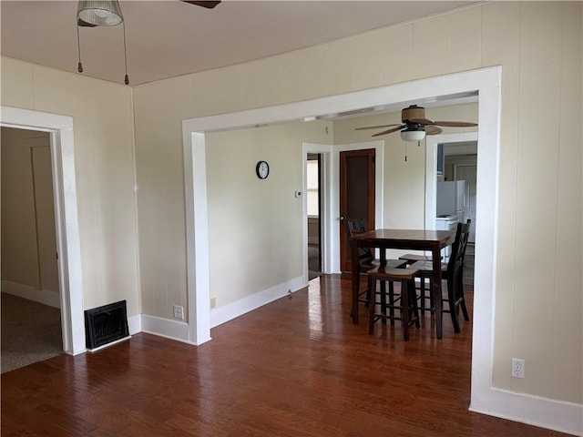 unfurnished dining area featuring baseboards, a ceiling fan, wood finished floors, and visible vents
