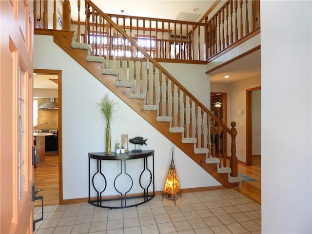 2405 W 123rd Ter, Leawood, KS 66209 - staircase featuring baseboards, a towering ceiling, and tile patterned flooring