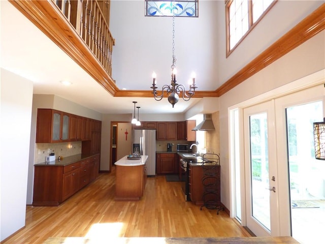 2405 W 123rd Ter, Leawood, KS 66209 - kitchen featuring stainless steel refrigerator with ice dispenser, a center island, light wood finished floors, and a high ceiling