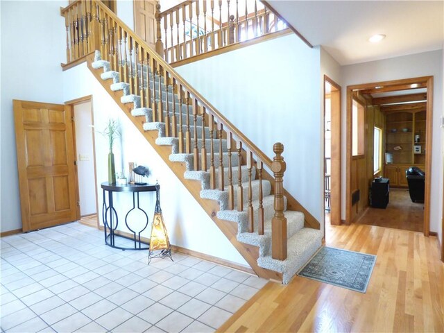 2405 W 123rd Ter, Leawood, KS 66209 - staircase featuring a towering ceiling, wood finished floors, baseboards, and recessed lighting
