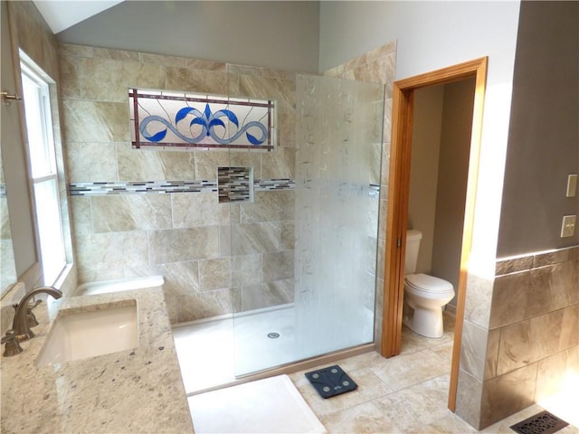 2405 W 123rd Ter, Leawood, KS 66209 - bathroom featuring vaulted ceiling, tile walls, a tile shower, toilet, and tile patterned flooring