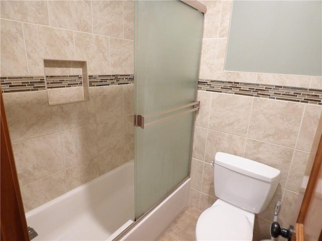 2405 W 123rd Ter, Leawood, KS 66209 - bathroom featuring toilet, combined bath / shower with glass door, and tile walls