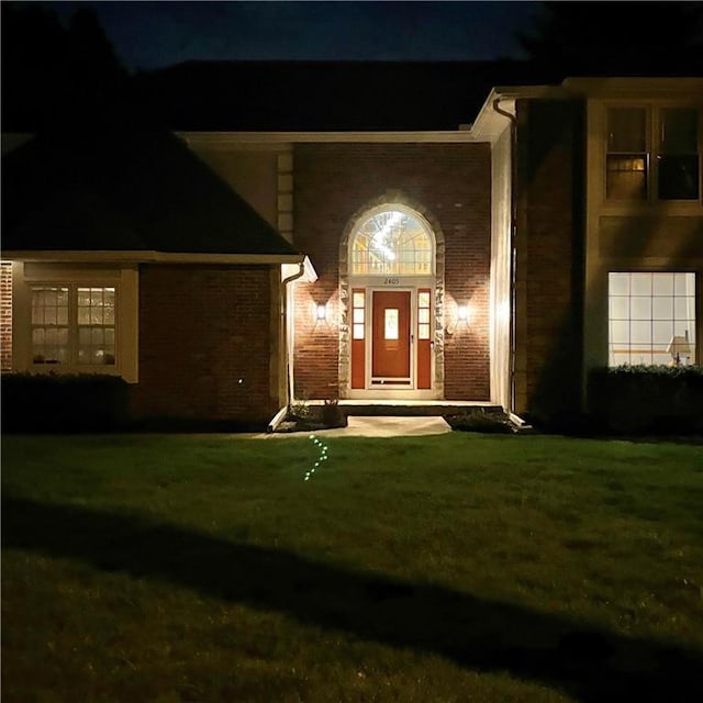 2405 W 123rd Ter, Leawood, KS 66209 - exterior entry at night with a lawn and brick siding
