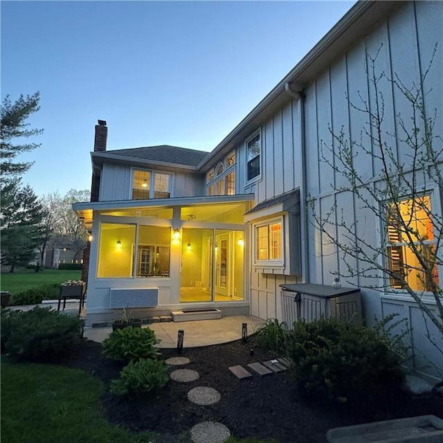 2405 W 123rd Ter, Leawood, KS 66209 - back of house featuring board and batten siding and a chimney