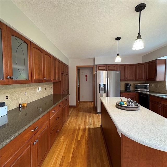 2405 W 123rd Ter, Leawood, KS 66209 - kitchen featuring glass insert cabinets, light wood-type flooring, pendant lighting, stainless steel appliances, and backsplash