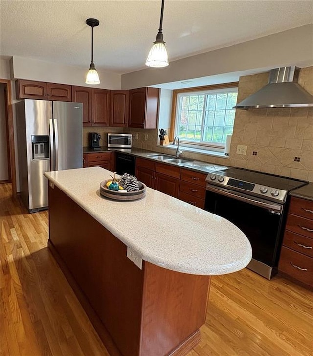 2405 W 123rd Ter, Leawood, KS 66209 - kitchen with a sink, light wood-style floors, backsplash, wall chimney exhaust hood, and appliances with stainless steel finishes