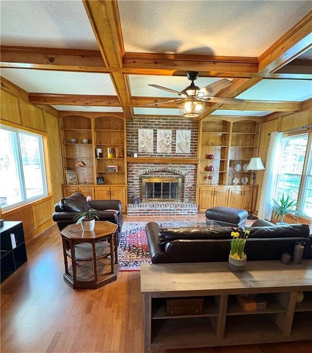 2405 W 123rd Ter, Leawood, KS 66209 - living room featuring coffered ceiling, built in features, wooden walls, and light wood-type flooring