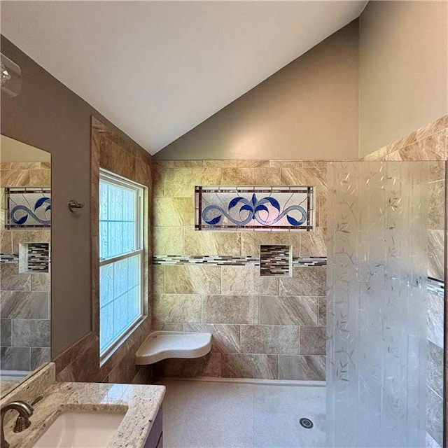 2405 W 123rd Ter, Leawood, KS 66209 - bathroom with a tile shower, vaulted ceiling, vanity, and tile walls